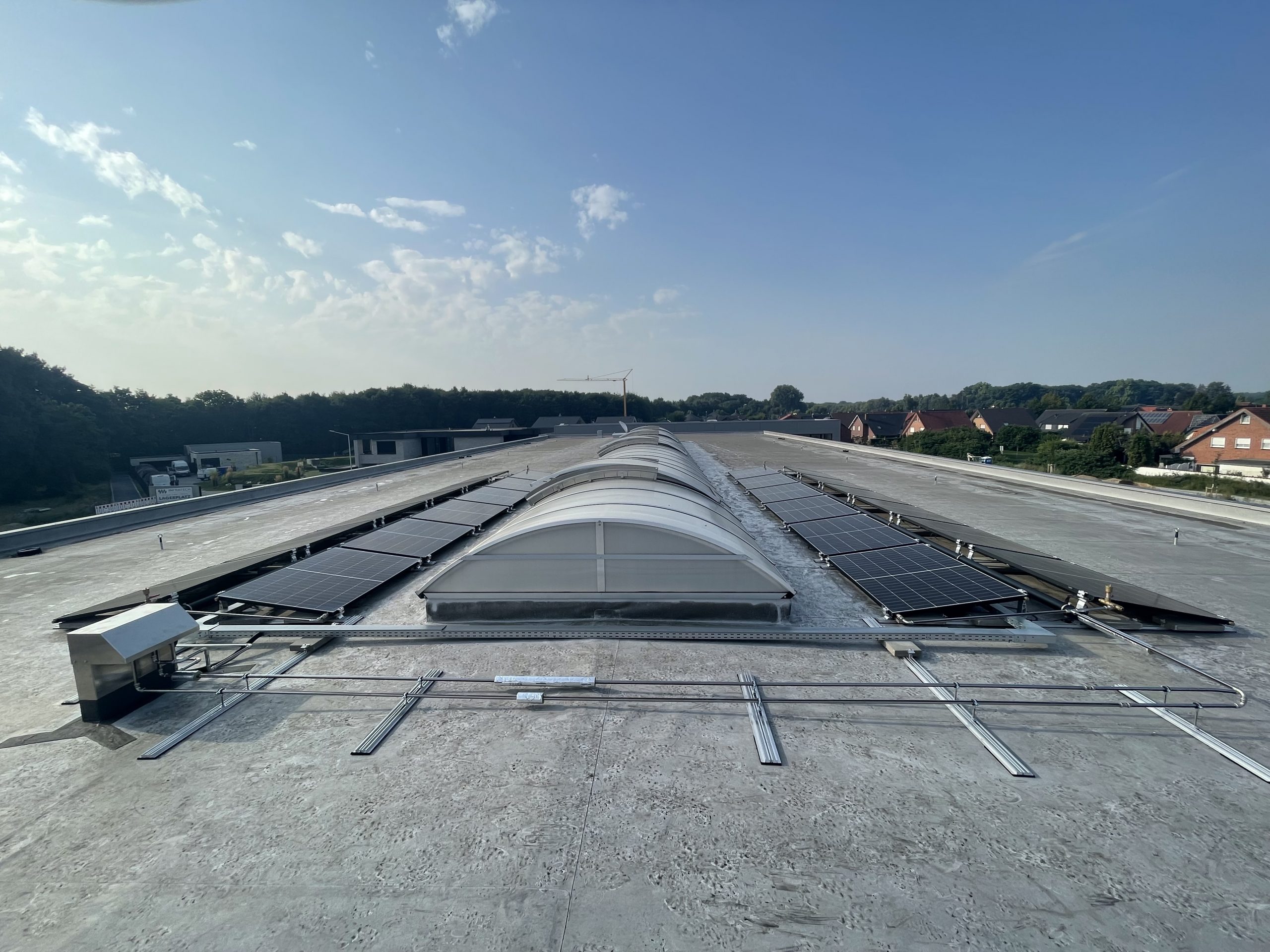Gewerbe- und Industriebauten in einer Straße mit PRISMA PVT und Sonne.