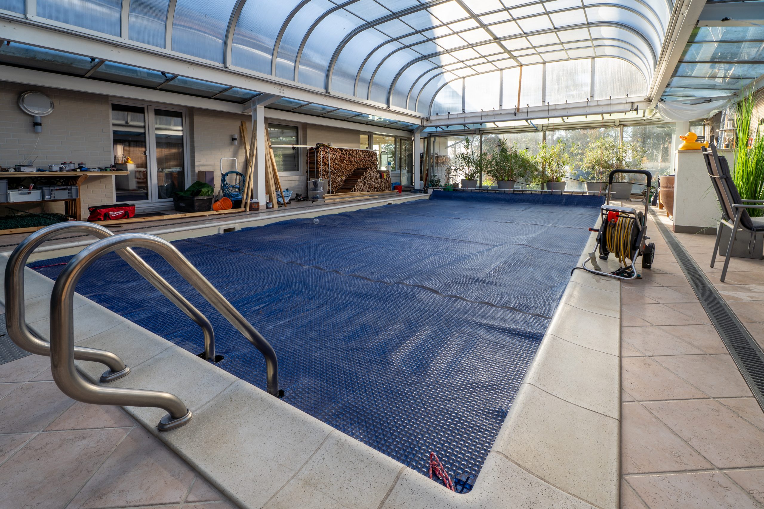 Einfamilienhaus mit Pool draußen. Der Pool wird beheizt mit PVT Kollektoren.